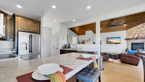 Una cocina moderna con una isla grande, electrodomésticos de acero inoxidable y armarios de madera.