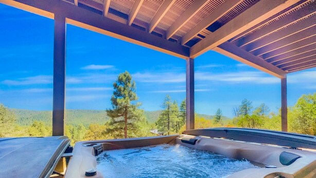 Un jacuzzi con vistas a un bosque y montañas.