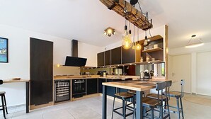 A modern kitchen with a central island, built-in appliances, and pendant lighting. - Brison-Saint-Innocent - L'Instant paisible (Brison-Saint-Innocent)