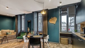 En moderne stue med spiseplads, store vinduer og udsigt over byen.