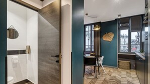 Et moderne køkken med spiseplads og udsigt over byen gennem store vinduer, samt et gulv med et fiskebensmønster.