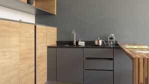 A modern kitchen with wooden cabinets, a black countertop, and a built-in sink. - Lapso Alarcon (Guadalajara)