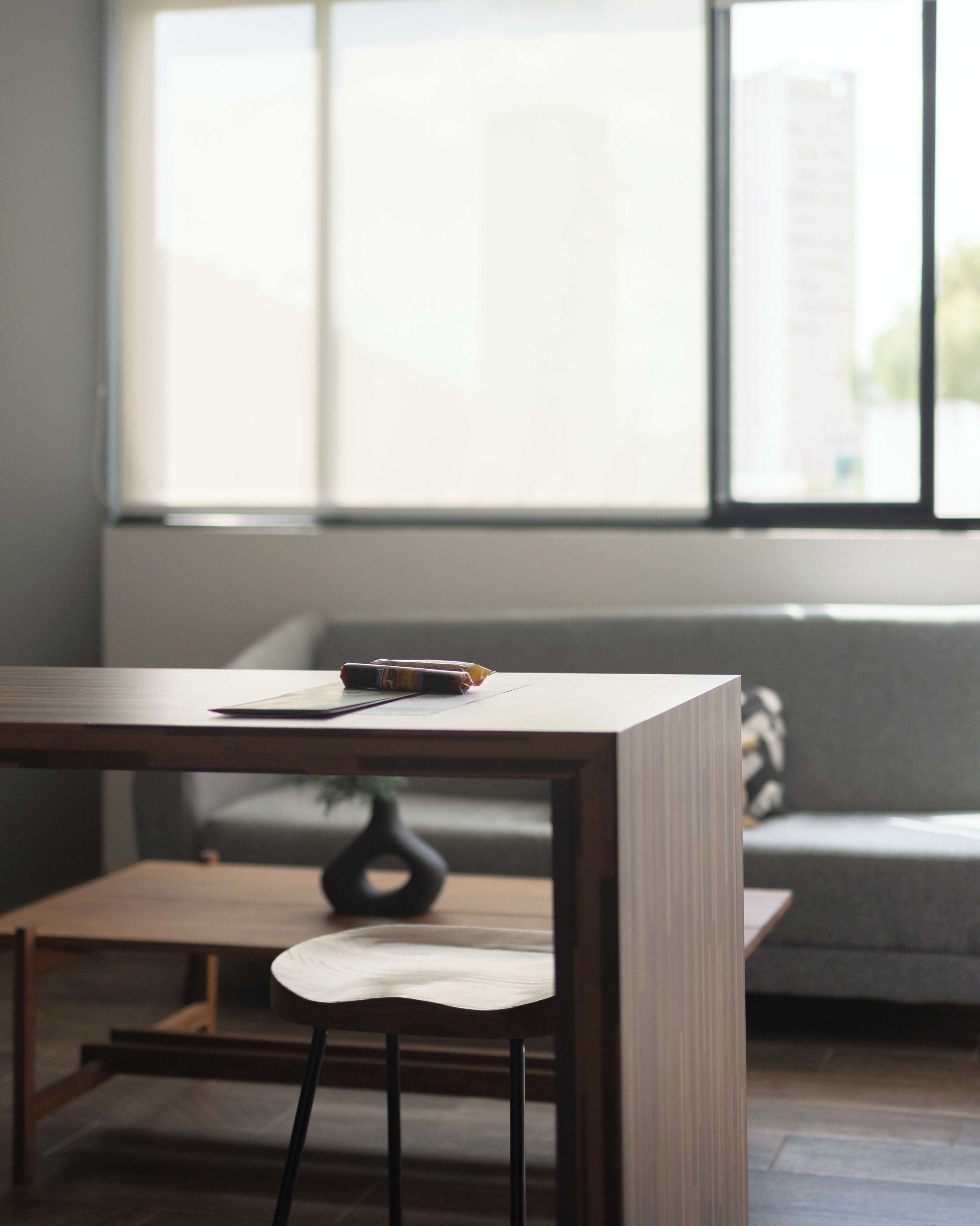 Una habitación moderna con un escritorio de madera, una silla y un sofá.