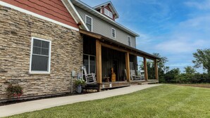 A two-story house with a stone facade, a covered porch, and a small attached garage.