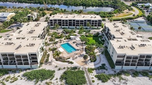 Un resort con piscina central, varias edificaciones y un paisaje natural circundante.