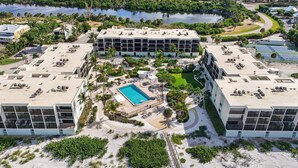 Ein Resort mit zentralem Pool, mehreren Gebäuden und einer umliegenden Naturlandschaft.