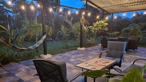 An outdoor patio with a hammock, chairs, and a table. - Villa Milagro (Provincia de Puntarenas)