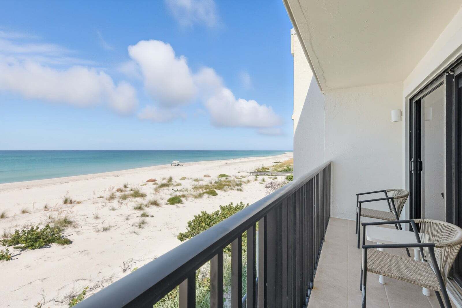 Ein Balkon mit Blick auf Strand und Meer.