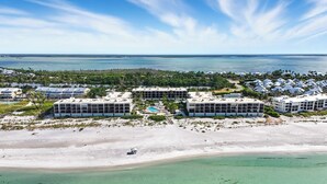 Un resort con varias construcciones, una playa y una vista despejada del océano.