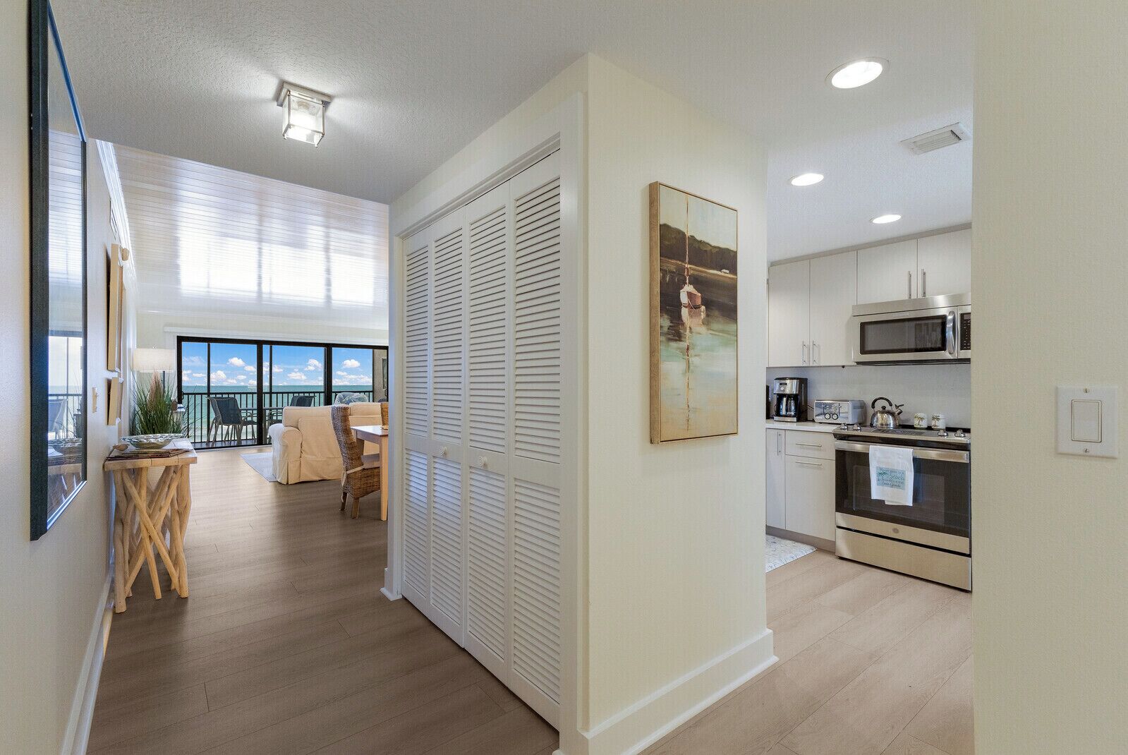 Un apartamento moderno con balcón, comedor y cocina equipada con electrodomésticos de acero inoxidable.