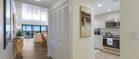 Un apartamento moderno con balcón, comedor y cocina equipada con electrodomésticos de acero inoxidable.