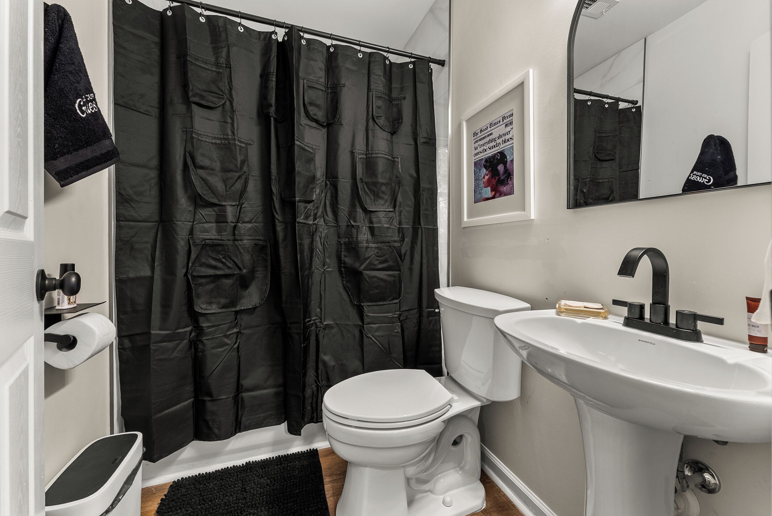 A bathroom with a white toilet, a sink, and a shower curtain with pockets.