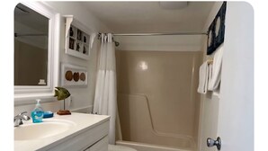 A bathroom with a white sink, a mirror, a toilet, and a bathtub. - Charming 1-bedroom condo in lovely Bonita Springs with WiFi, AC pool. And tennis (Bonita Springs)