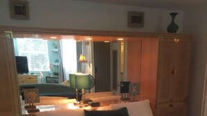 A bedroom with a bed, a nightstand, a lamp, a dresser, and a mirror. - Charming 1-bedroom condo in lovely Bonita Springs with WiFi, AC pool. And tennis (Bonita Springs)