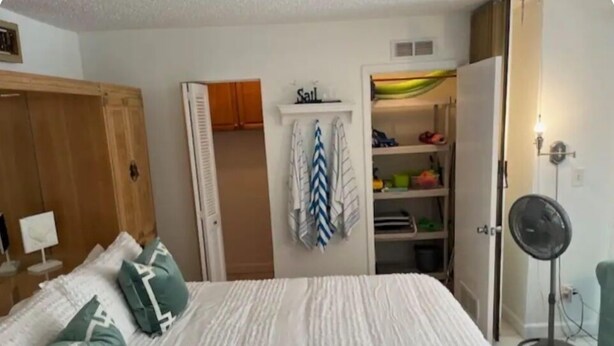 A bedroom with a bed, a wardrobe, a closet, and a fan. - Charming 1-bedroom condo in lovely Bonita Springs with WiFi, AC pool. And tennis (Bonita Springs)