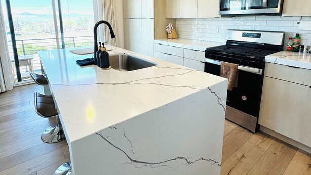 A modern kitchen with a large island, stainless steel appliances, and a view to the outside. - NEW Modern 3 bed Home with Stunning Mountain Views close to Ski Resort and City (Sandy)