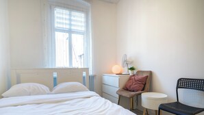 A bedroom with a bed, a desk, a chair, and a bedside table. - Silesian Charm Kozielska 1 Studio (Katowice)