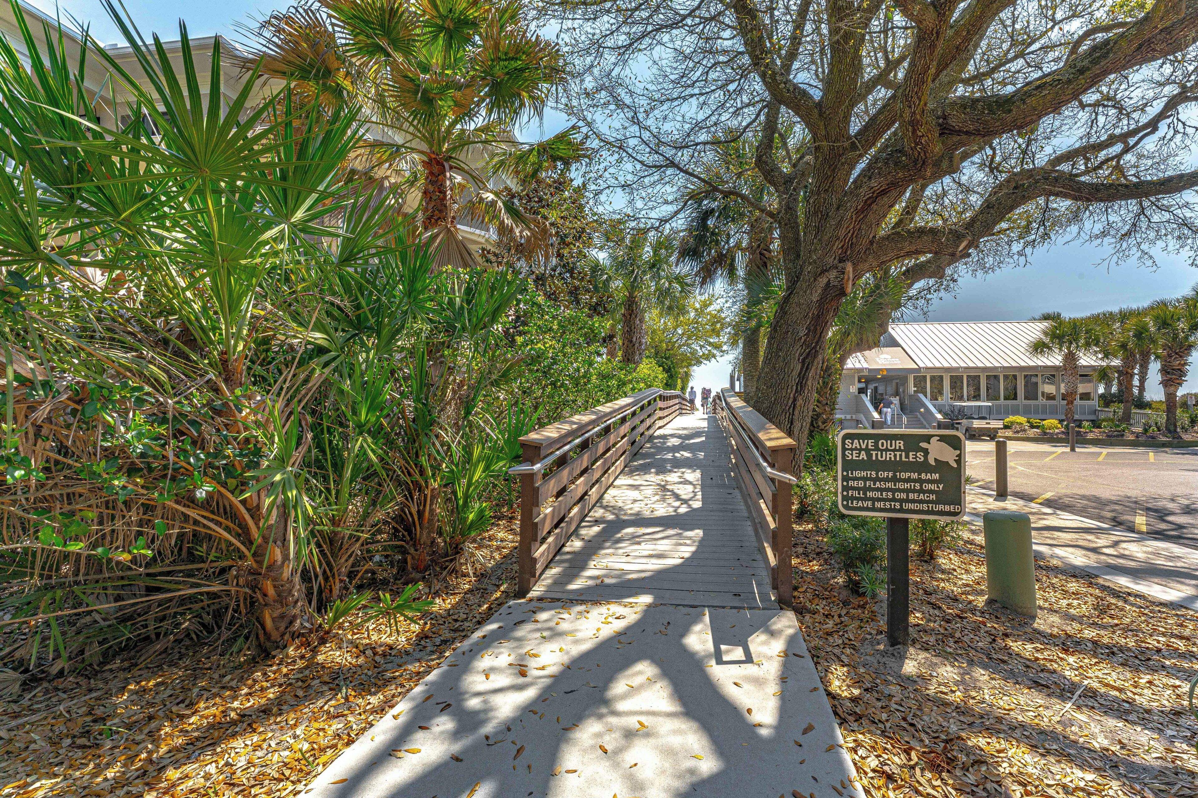 A wooden boardwalk with a sign about sea turtle conservation.
