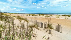 A beach with sand dunes, a wooden fence, and the ocean in the background. - Family Villa | Deck, Lagoon Views, Complex Pool, Bikes (Hilton Head Island)
