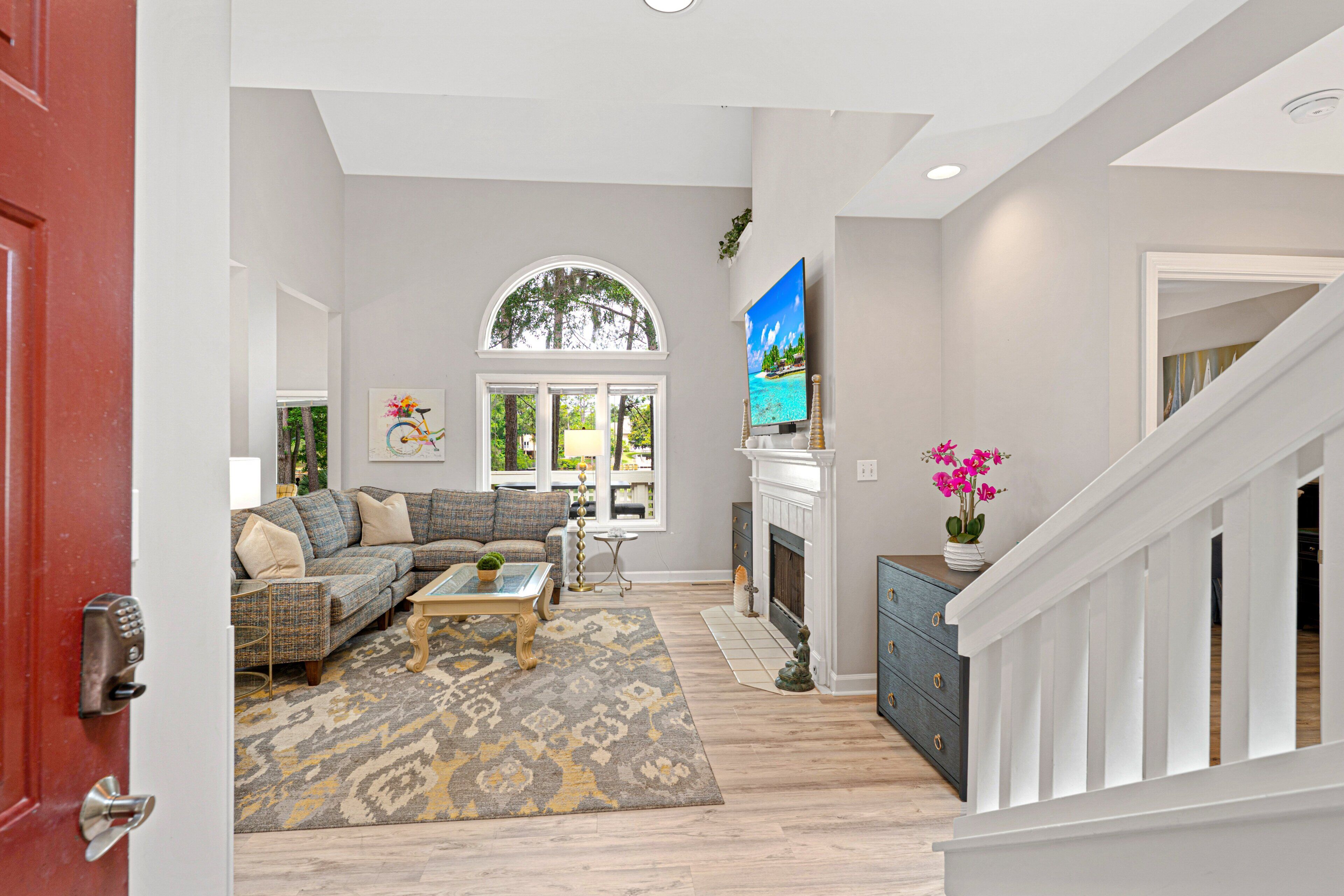 A living room with a sofa, coffee table, fireplace, and a staircase.