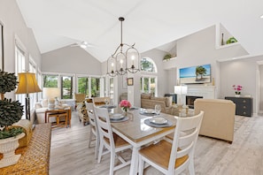 A spacious living area with a dining table, chairs, a sofa, and a television.