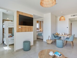 A modern hotel room with a bunk bed, a dining area with a table and chairs, a round coffee table with a book and glasses, and a large window. - Résidence Odalys Collection Riviera by Interhome (Hyères)