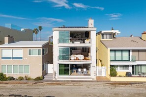 A multi-story residential building with balconies, large windows, and a visible pool area. - 3 Story Single Family Home with Sauna, AC, and Private Gated Parking (Long Beach)