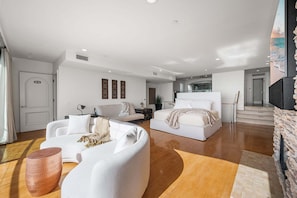 A spacious living room with a large bed, a sofa, and a coffee table. - Panoramic Ocean Views with Sauna, AC, and Parking (Long Beach)