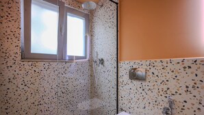 A bathroom with a shower, a toilet, and a window. - Grandstay Studio 110 (Durrës)