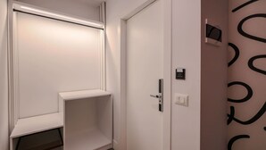 A white door with a handle, a small control panel, and a light switch on the wall. - Grandstay Studio 112 (Durrës)