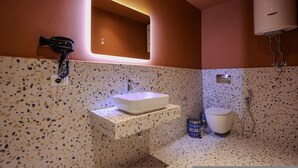 Ein Badezimmer mit Waschbecken, Spiegel, Handtuchhalter, Toilette und Dusche.