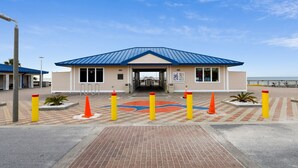 A building with a blue roof, beige walls, and a brick entrance area.