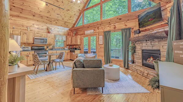 A cabin interior with a kitchen, dining area, and living room.
