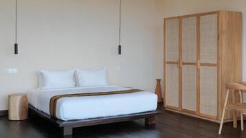 Ein Schlafzimmer mit Bett, Nachttischen, einem Kleiderschrank und einem Sessel.