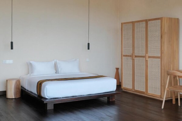 A bedroom with a bed, bedside tables, a wardrobe, and a chair. - DUNIA LOMBOK (Selong Belanak)