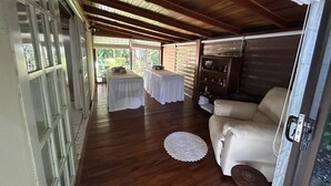 Ein Korridor mit Holzboden, der zu einer Sitzecke mit einer Couch und Tischen führt.