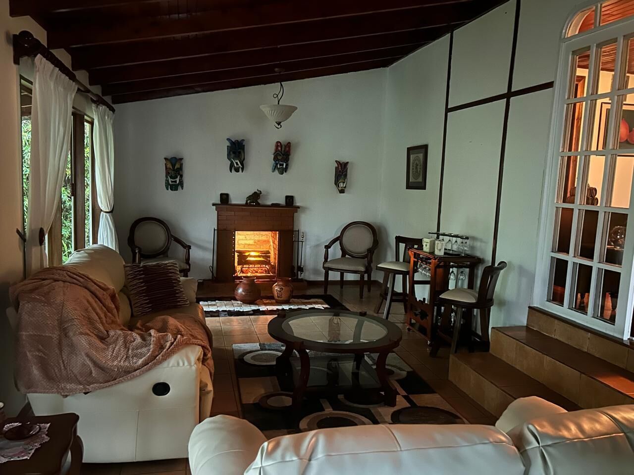 A cozy living room with a fireplace, comfortable seating, and a dining area.
