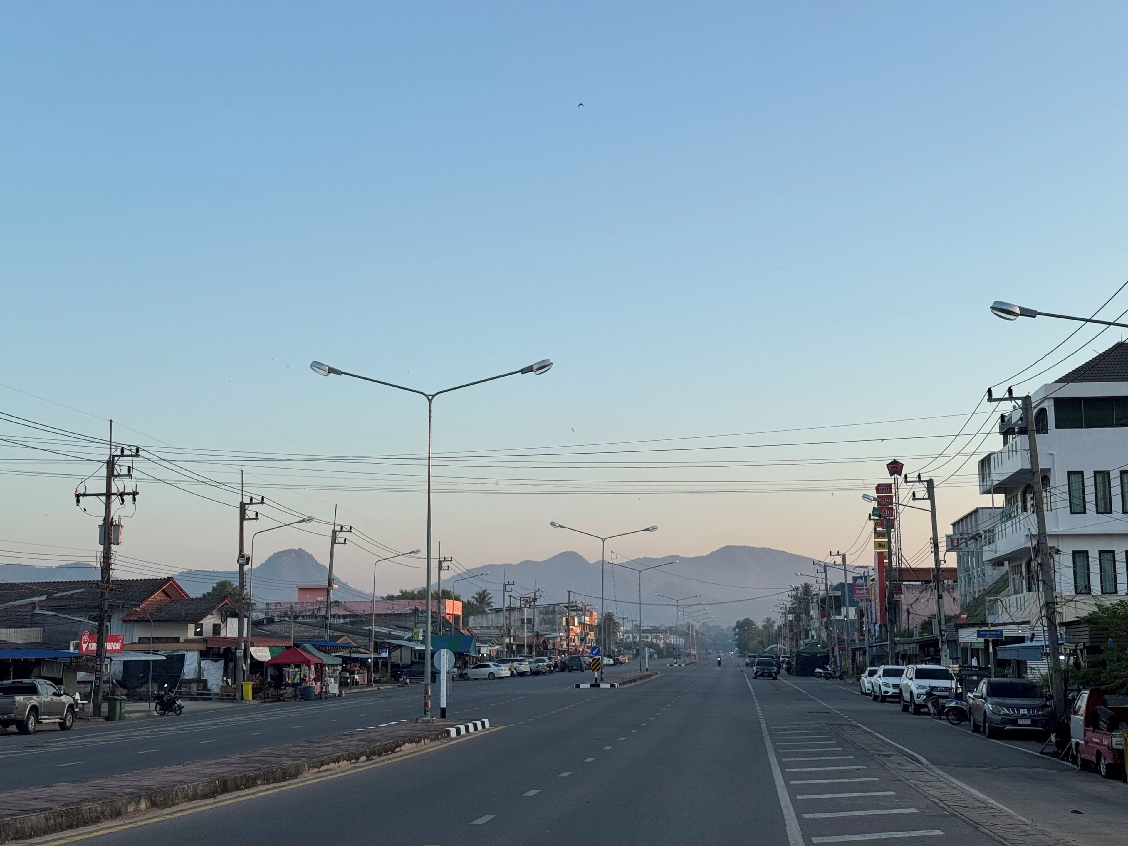 A street view with buildings, vehicles, and streetlights.