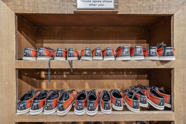 Un zapatero con zapatos numerados y un letrero que indica rociar los zapatos después de usarlos.