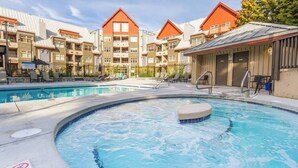 A hotel with a swimming pool, outdoor seating, and a sauna. - Modern Air-Conditioned Ski In/Out 1 BR: Sleeps 4, King bed, Hot Tub, Pool! (Whistler)