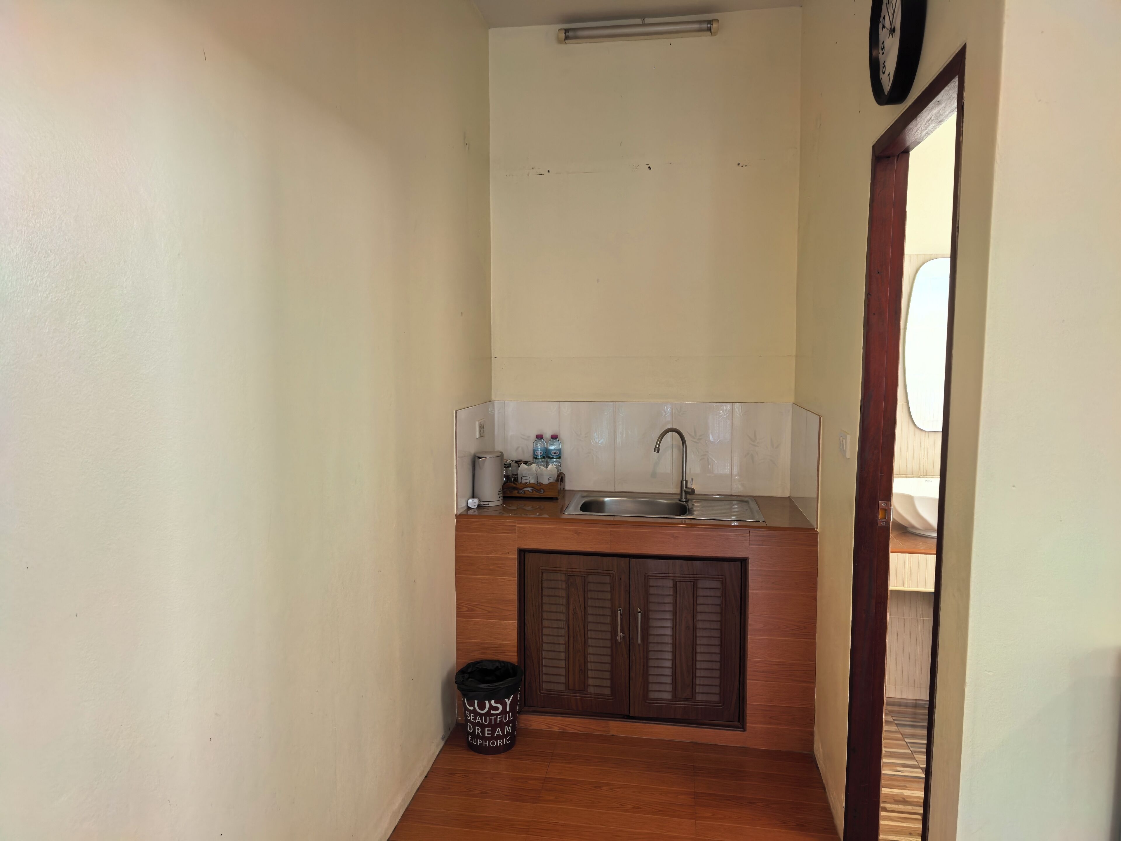 A compact kitchen with a sink, countertop, and cabinets.