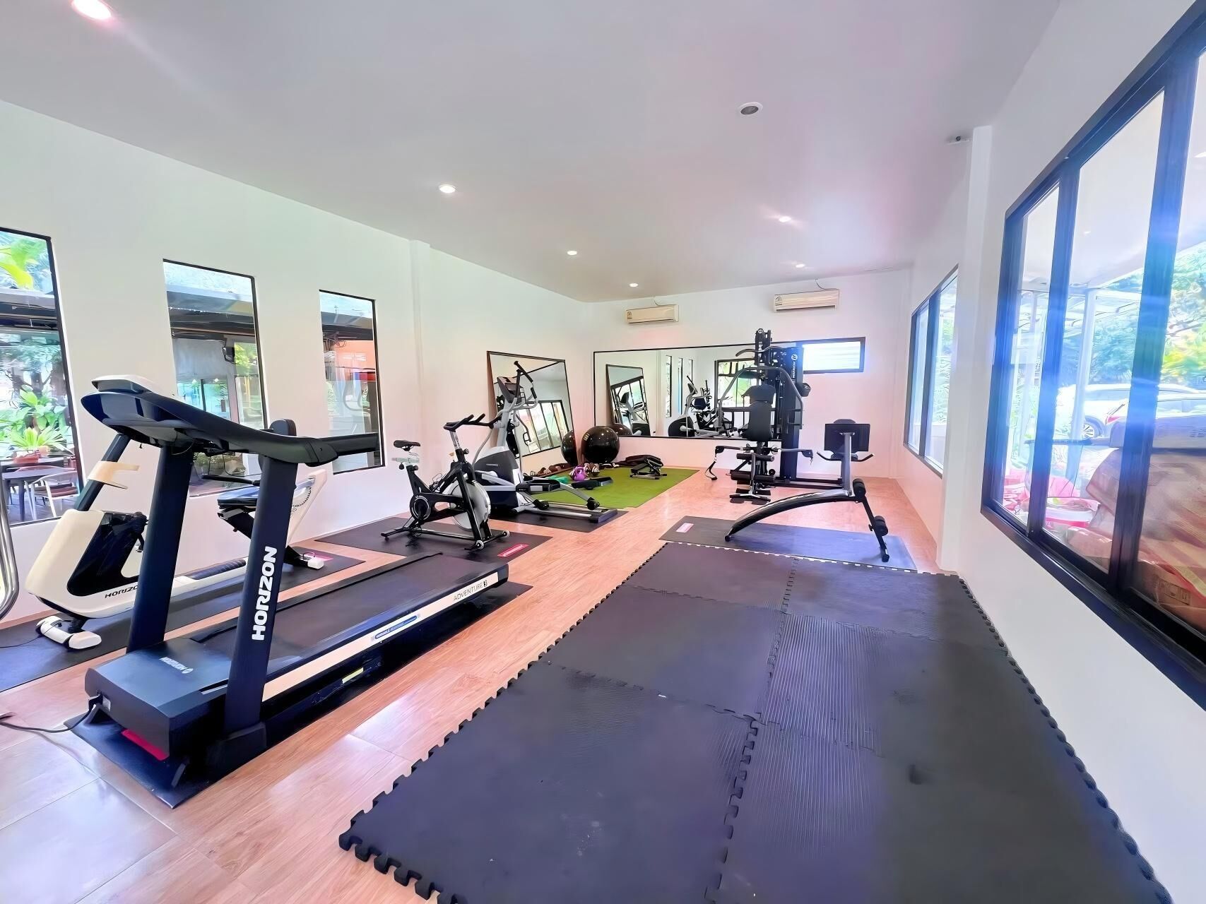 Un gimnasio moderno con cintas de correr, bicicletas estáticas y máquinas de pesas.