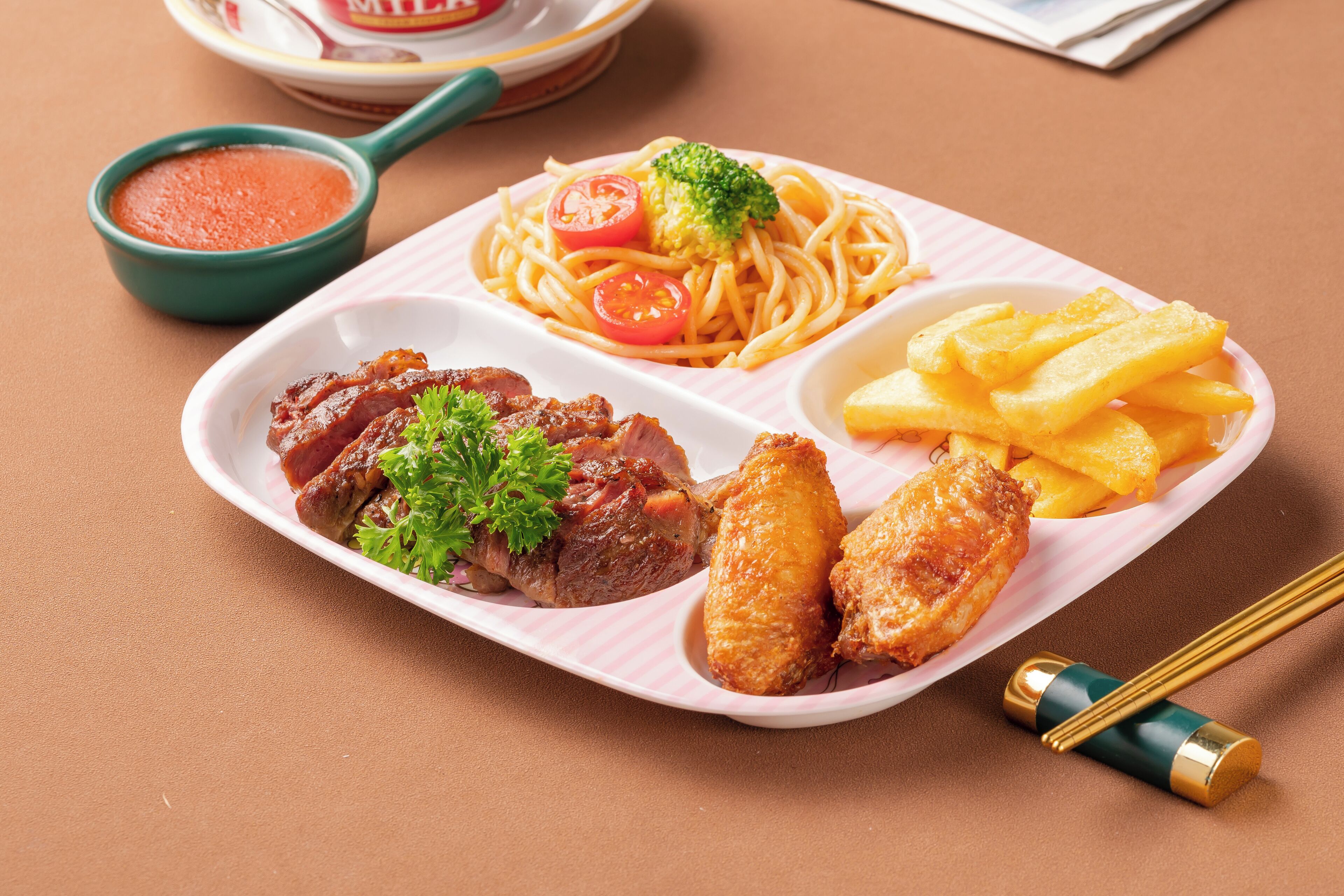 A meal with spaghetti, fries, and meat, served on a white plate with a striped pattern.