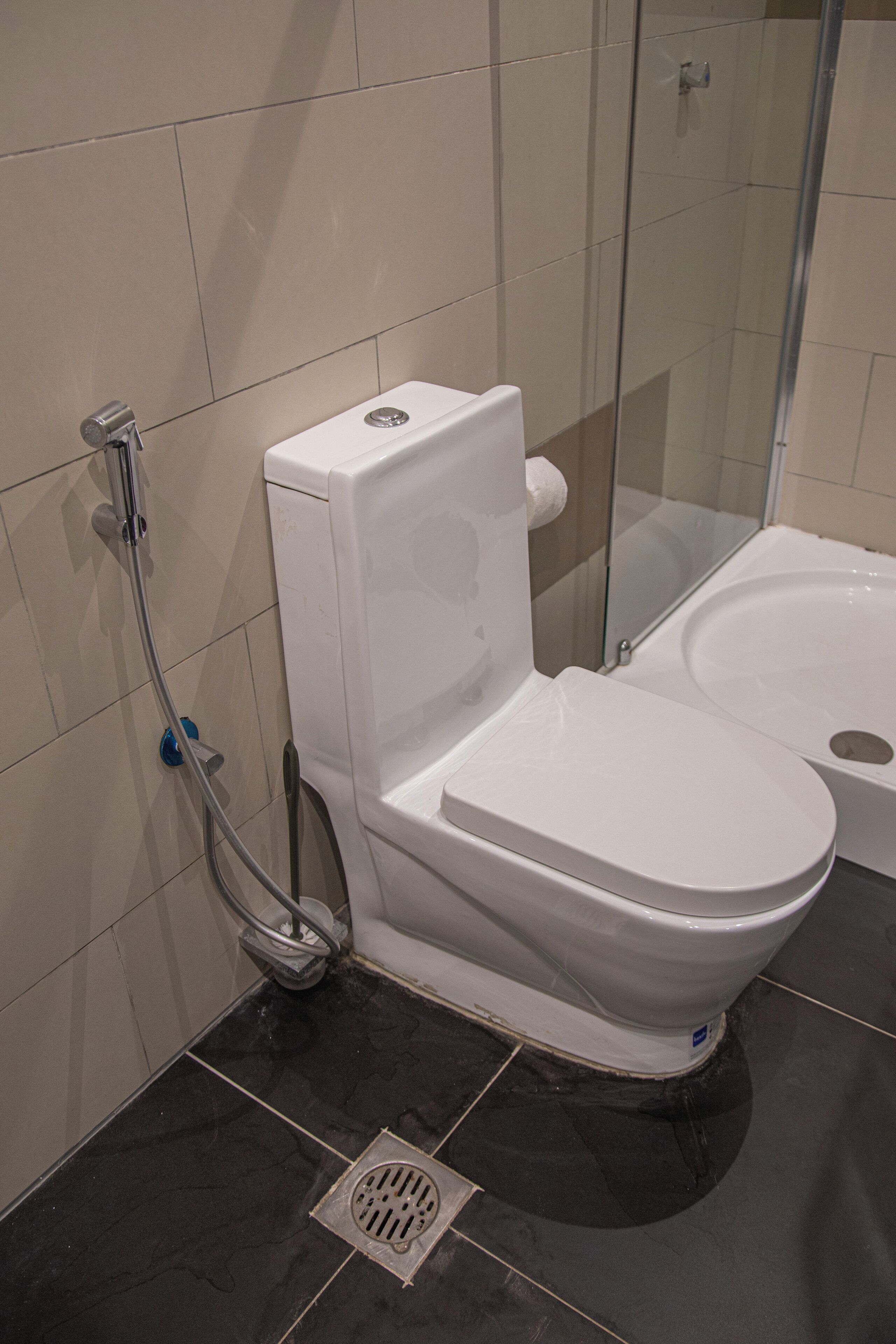 A modern bathroom with a toilet, shower, and bidet.