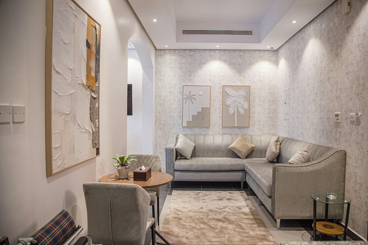 Una sala de estar moderna con un sofá modular, una mesa de centro redonda y una alfombra estampada.
