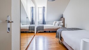 A modern bedroom with a bed, bedside table, and a window with curtains. - Blueground | Zurich town hall, city view, nr Rathaus (Zurich)