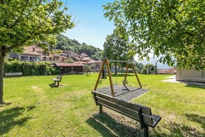 A park with a swing set, benches, and a playground.