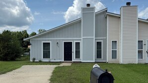 A two-story house with a front porch, a mailbox, and a clear sky. - 2 Bedroom Hideaway in Jacksonville (Jacksonville)
