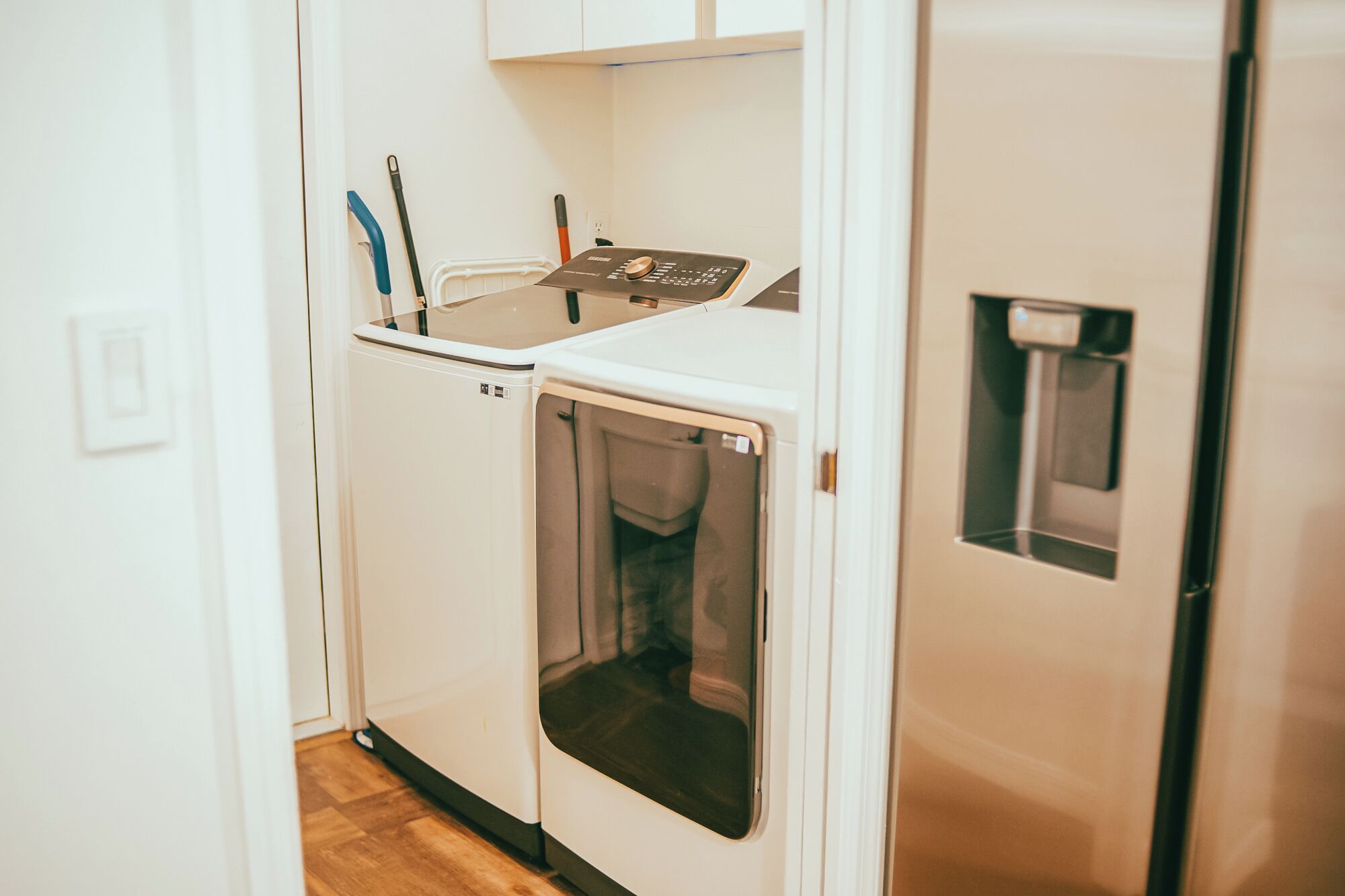 A compact laundry room with a washing machine, dryer, and a water dispenser.