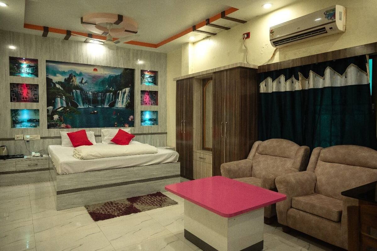 A modern bedroom with a bed, a desk, and a sofa.